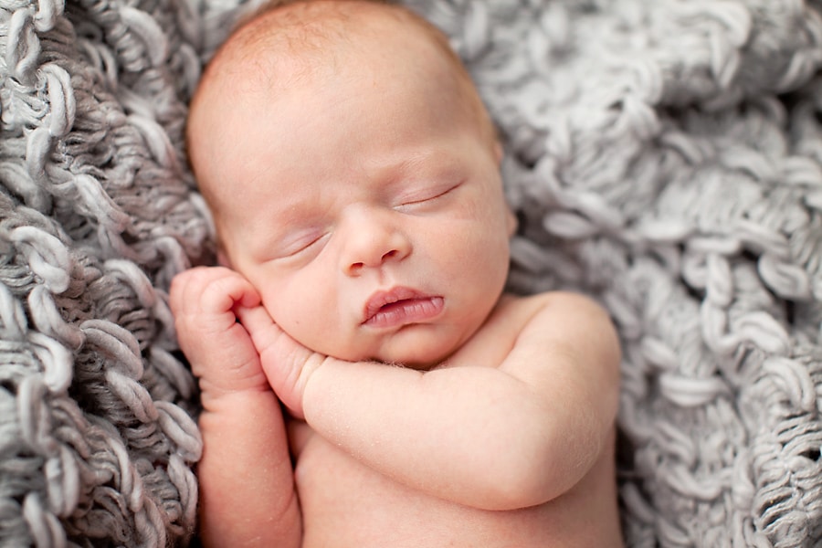 snuggly little guy in mid-century newborn session