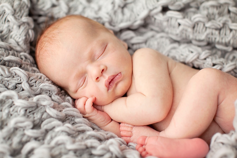 snuggly little guy in mid-century newborn session