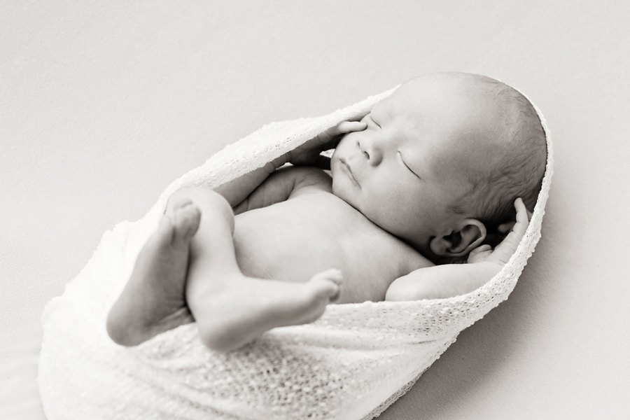 beautiful newborn baby boy snuggled up for photoshoot in private Dallas Studio session