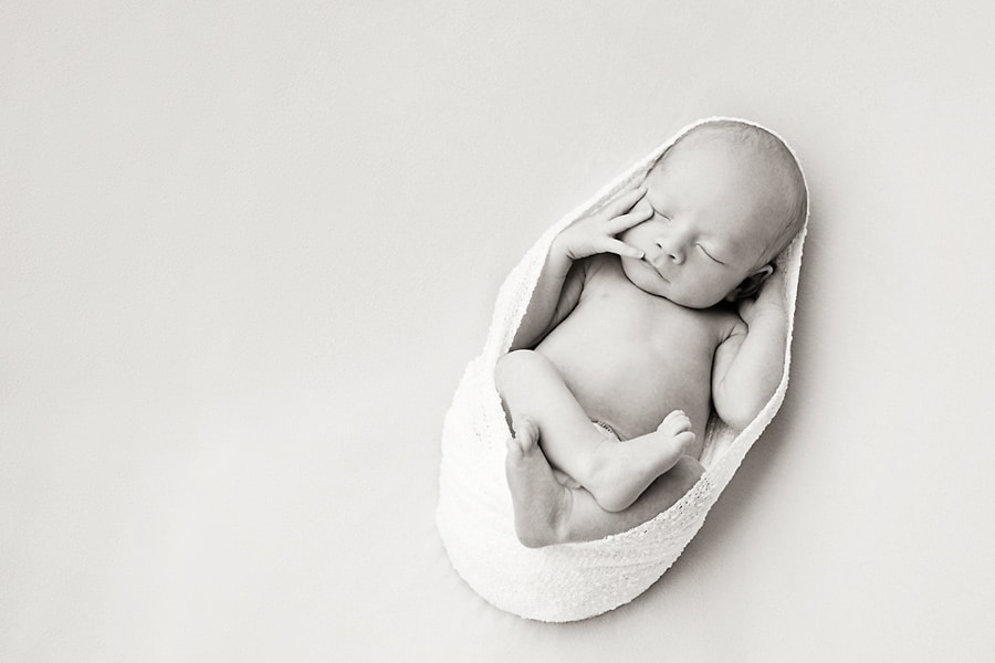 beautiful newborn baby boy snuggled up for photoshoot in private Dallas Studio session