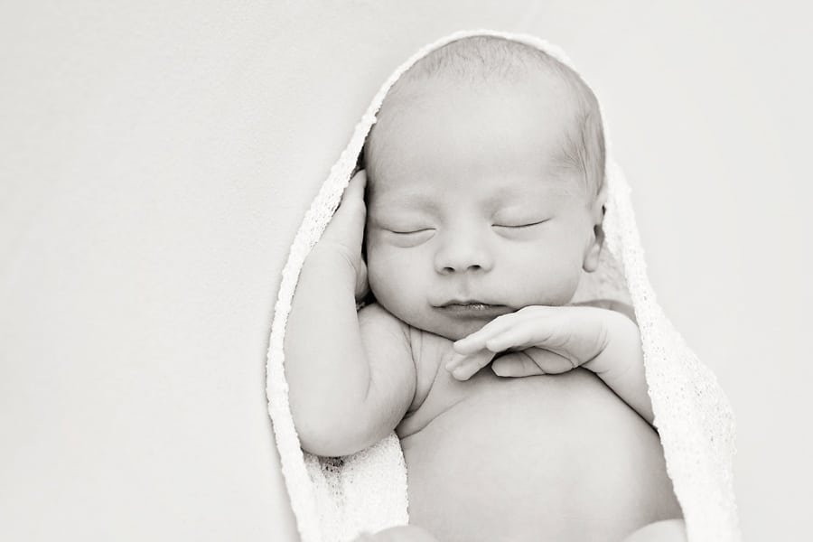 beautiful newborn baby boy snuggled up for photoshoot in private Dallas Studio session
