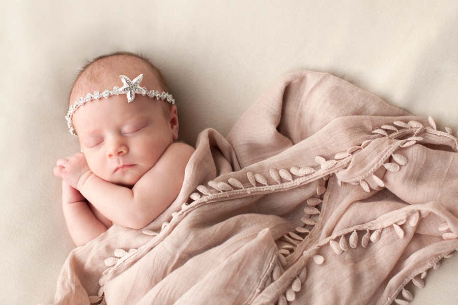 cutest newborn baby girl posing snuggled up with mermaid in Dallas Studio