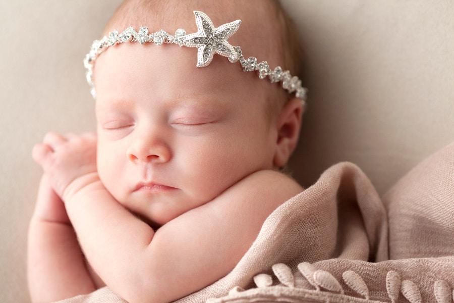 cutest newborn baby girl posing snuggled up with mermaid in Dallas Studio