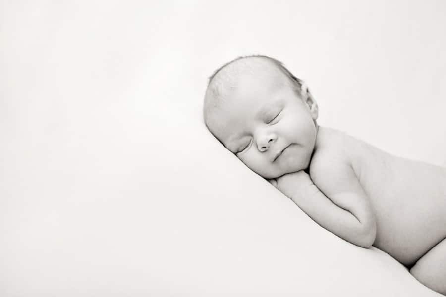 cutest newborn baby girl posing snuggled up with mermaid in Dallas Studio