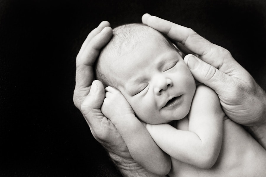 beautiful newborn baby posing in private studio session with parents