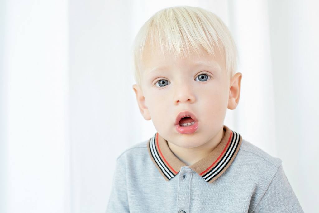 big brother posing for camera in family session at studio