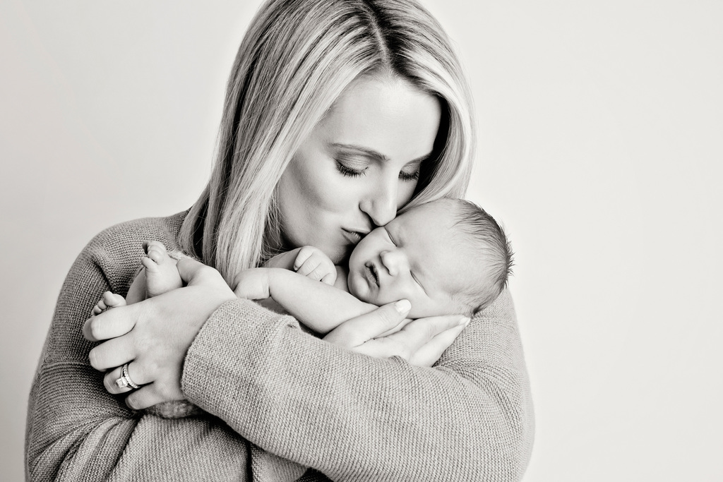 sweet mom loving on her newborn baby during family session