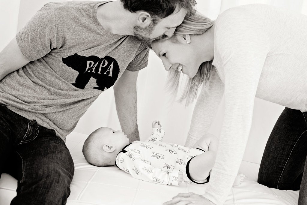 mom and dad showing off baby in private studio session