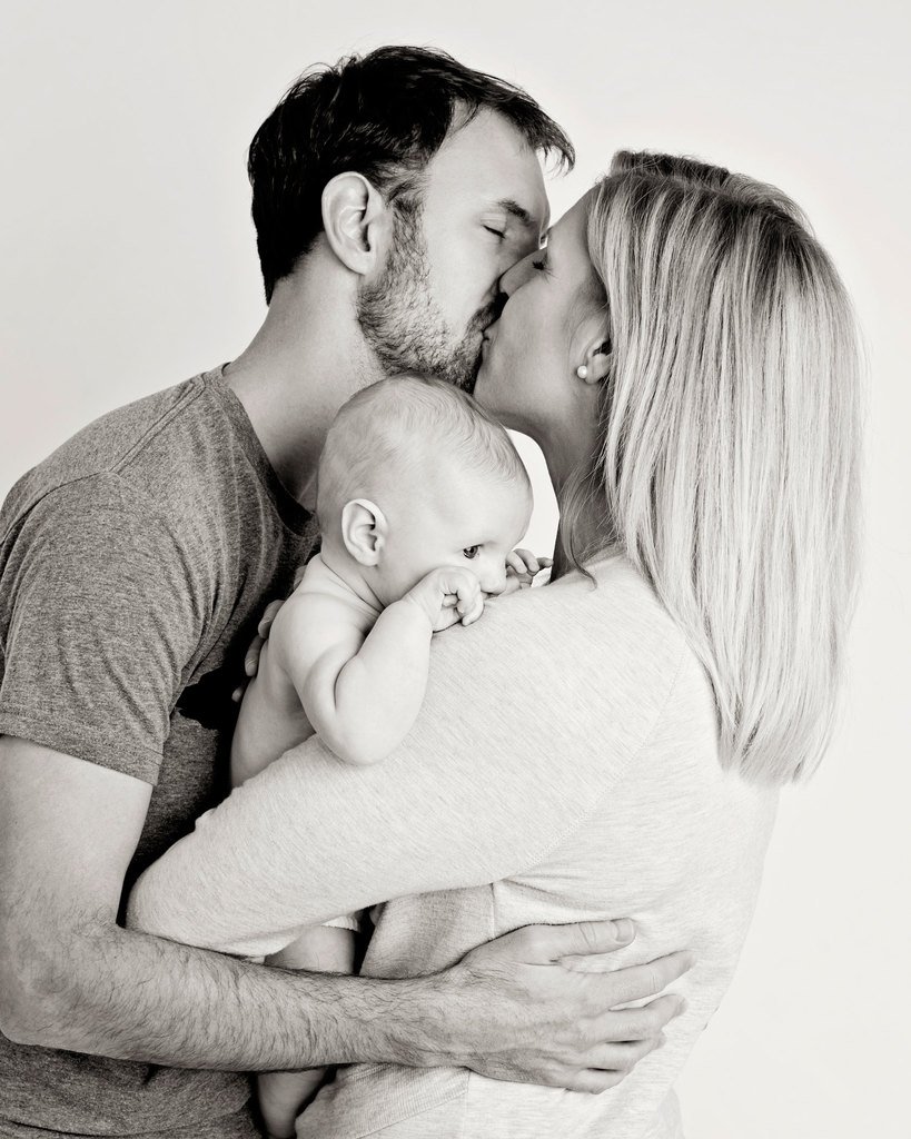 mom and dad showing off their new baby in private studio session