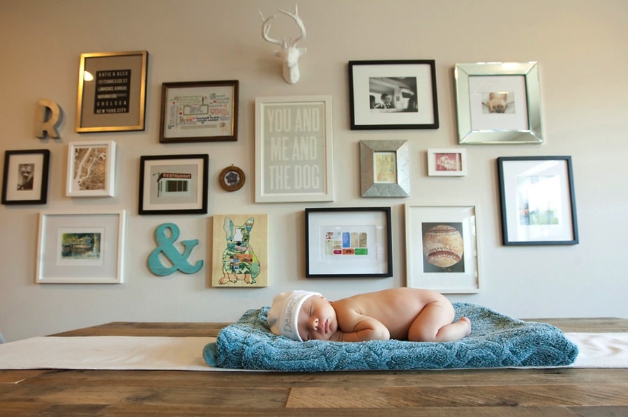 beautiful gallery wall behind newborn in at home newborn session