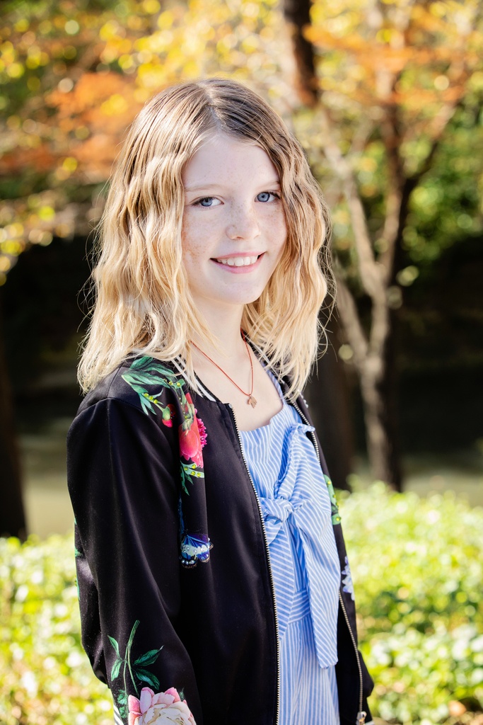 Young girl poses outside in fall family session