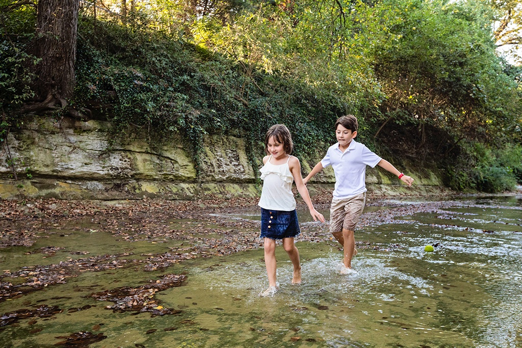 kids play outside for family session in creek