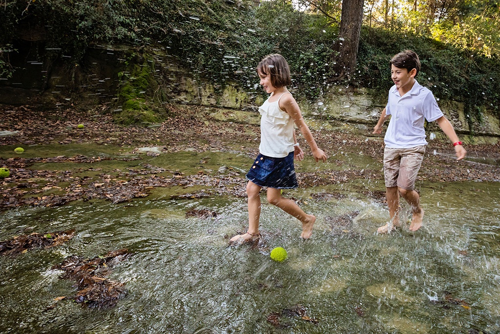 kids play outside for family session in creek
