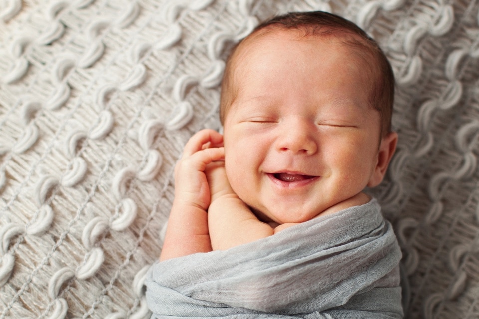 grinning sleepy baby in private studio