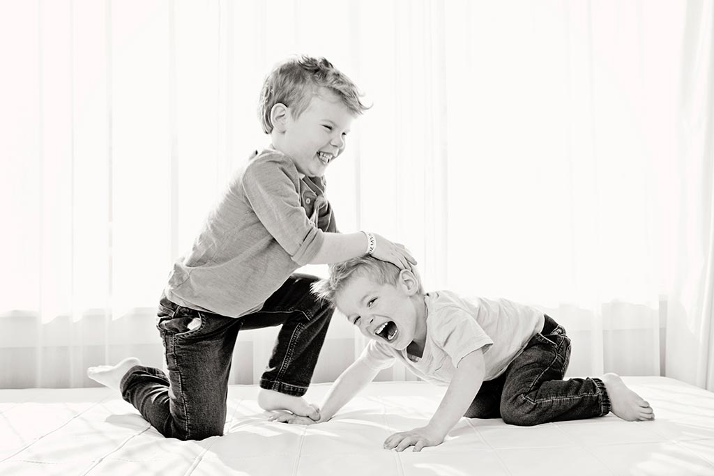 young boys wrestling in black and white family photo