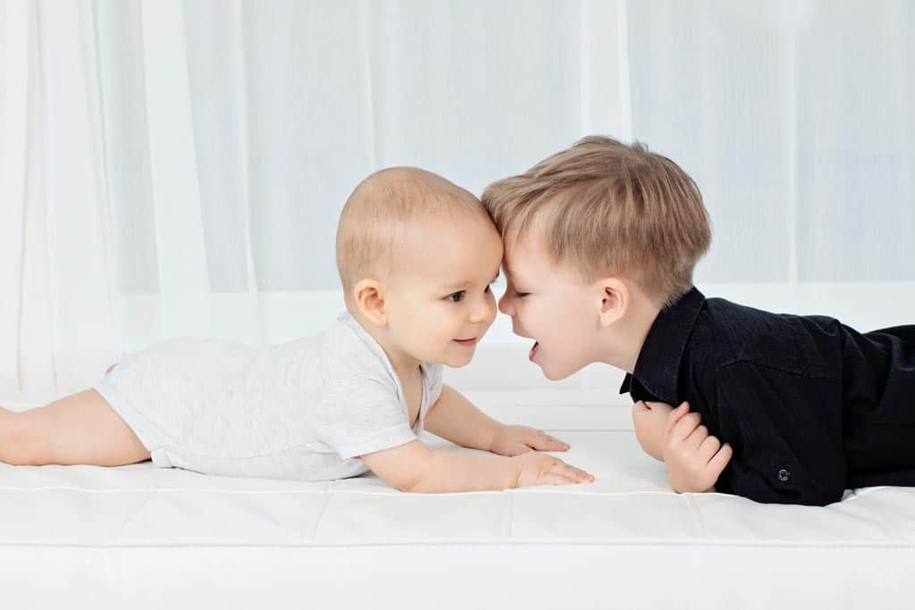 six-month old and his big brother pose in private studio for adorable and memorable photos