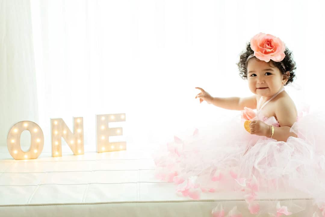 cute little girl wearing big tutu and detailed one sign on her first birthday