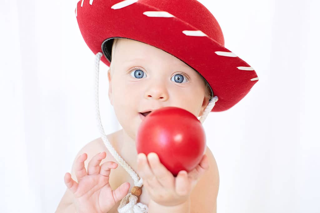 cute little boy with red cowboy hat posing in the studio