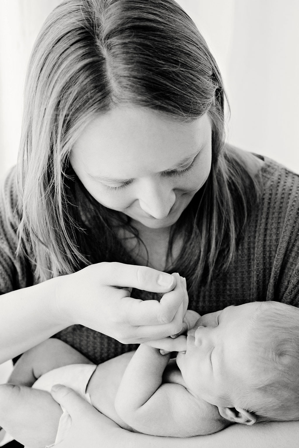adorable tender moment between baby and mom in private newborns session