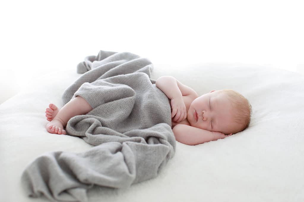 sweet tender baby all snuggled up for newborn session in private dallas studio