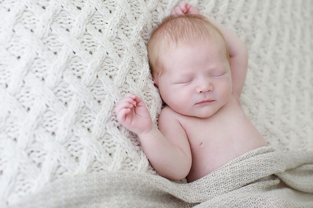 sweet tender baby all snuggled up for newborn session in private dallas studio