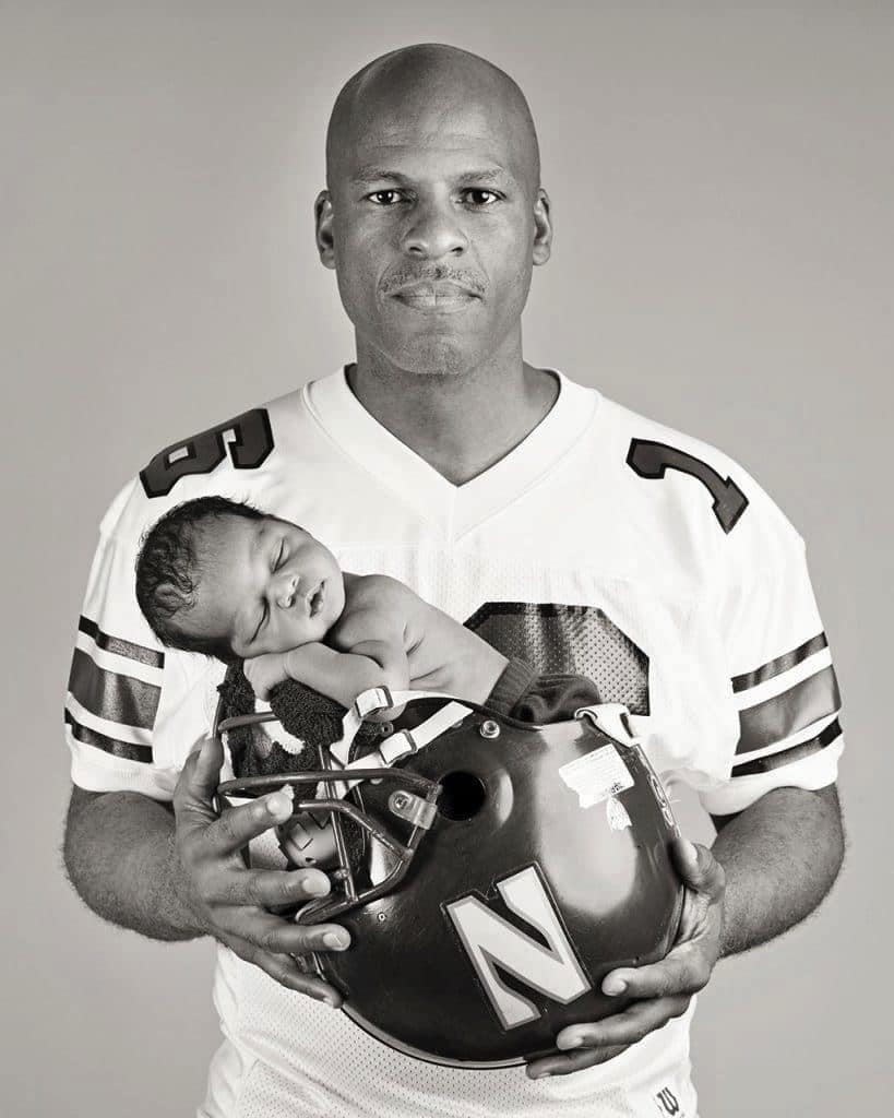 Dad poses with baby in football helmet for a gorgeous personality-filled session