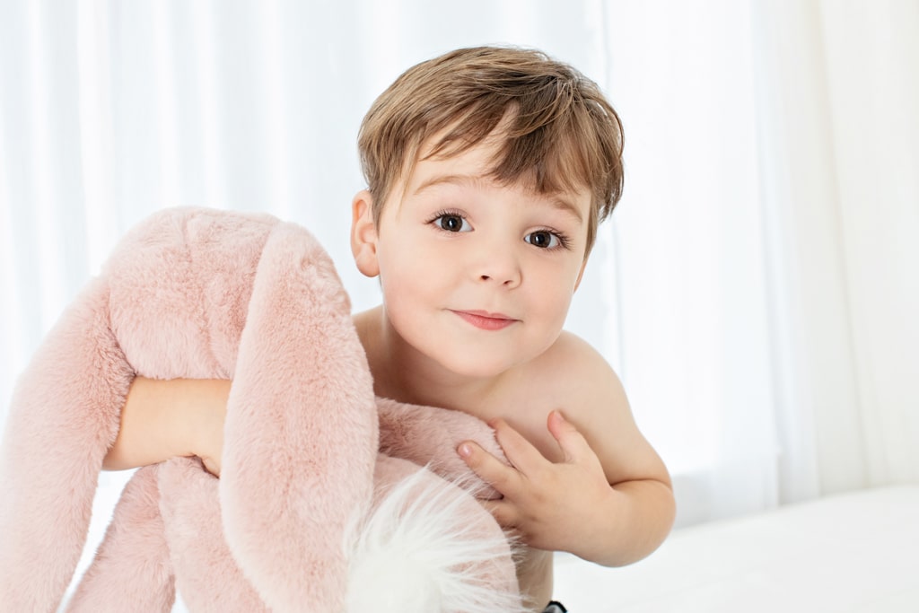 adorable little boy cuddles up with stuffed bunny