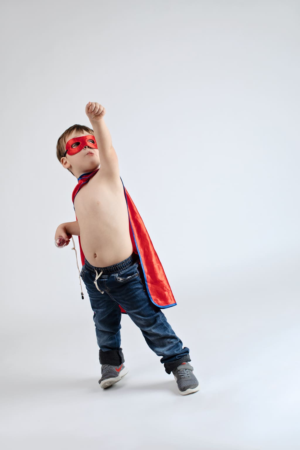 young boy dressed up as superhero plays around in the studio