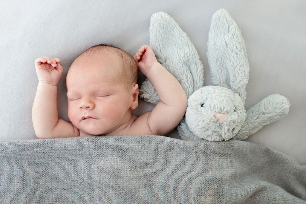 newborn baby boy snuggled up with bunny