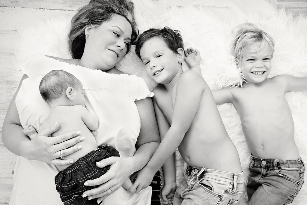 Mom poses with two of her boys and her newborn son in dallas studio session