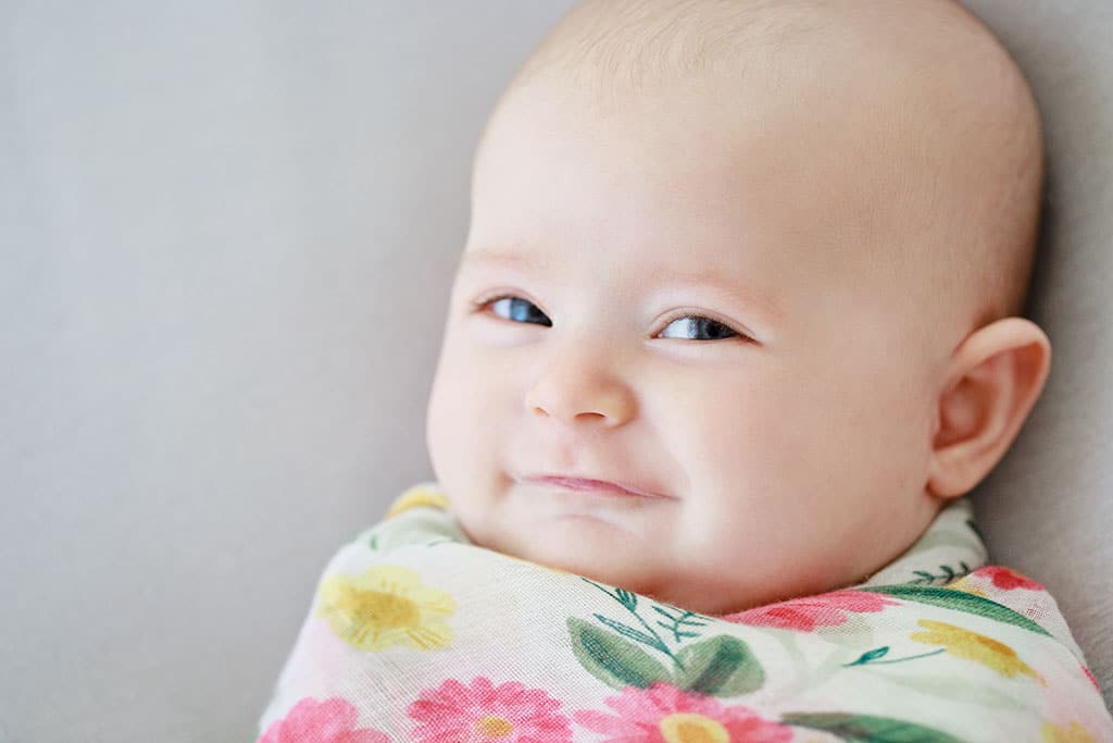 newborn girl smiling at Camera