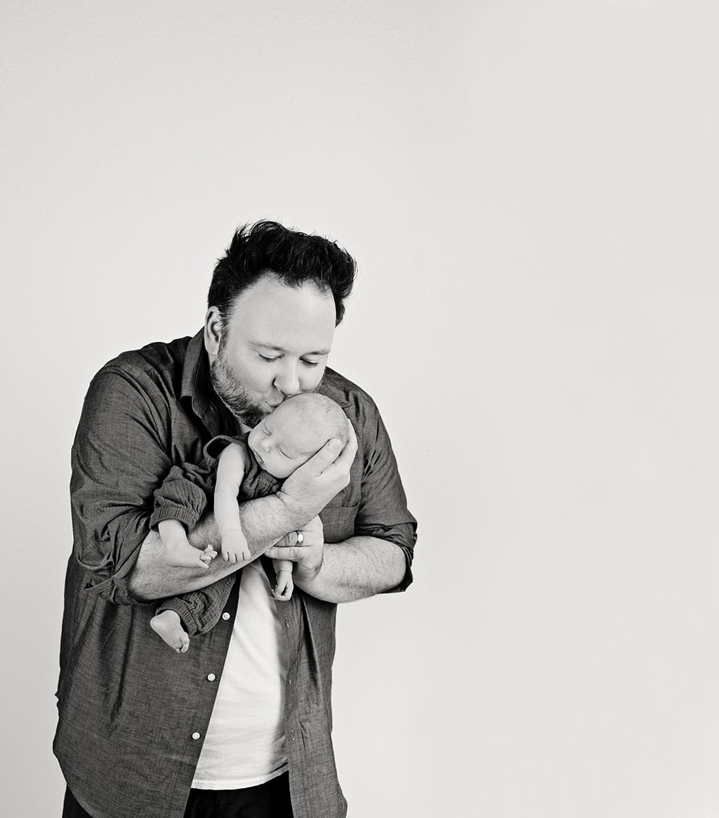 very smitten dad holding newborn baby boy