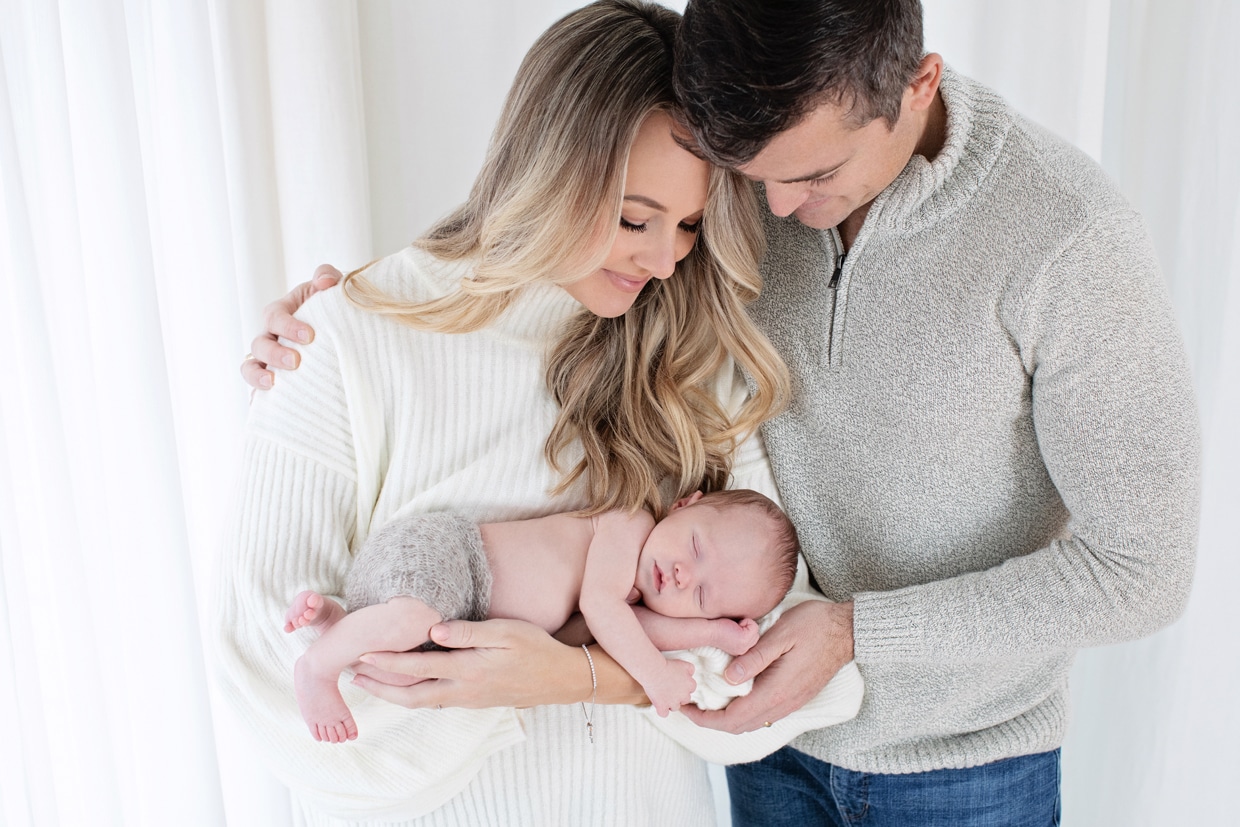 mom and dad admire their gorgeous newborn baby