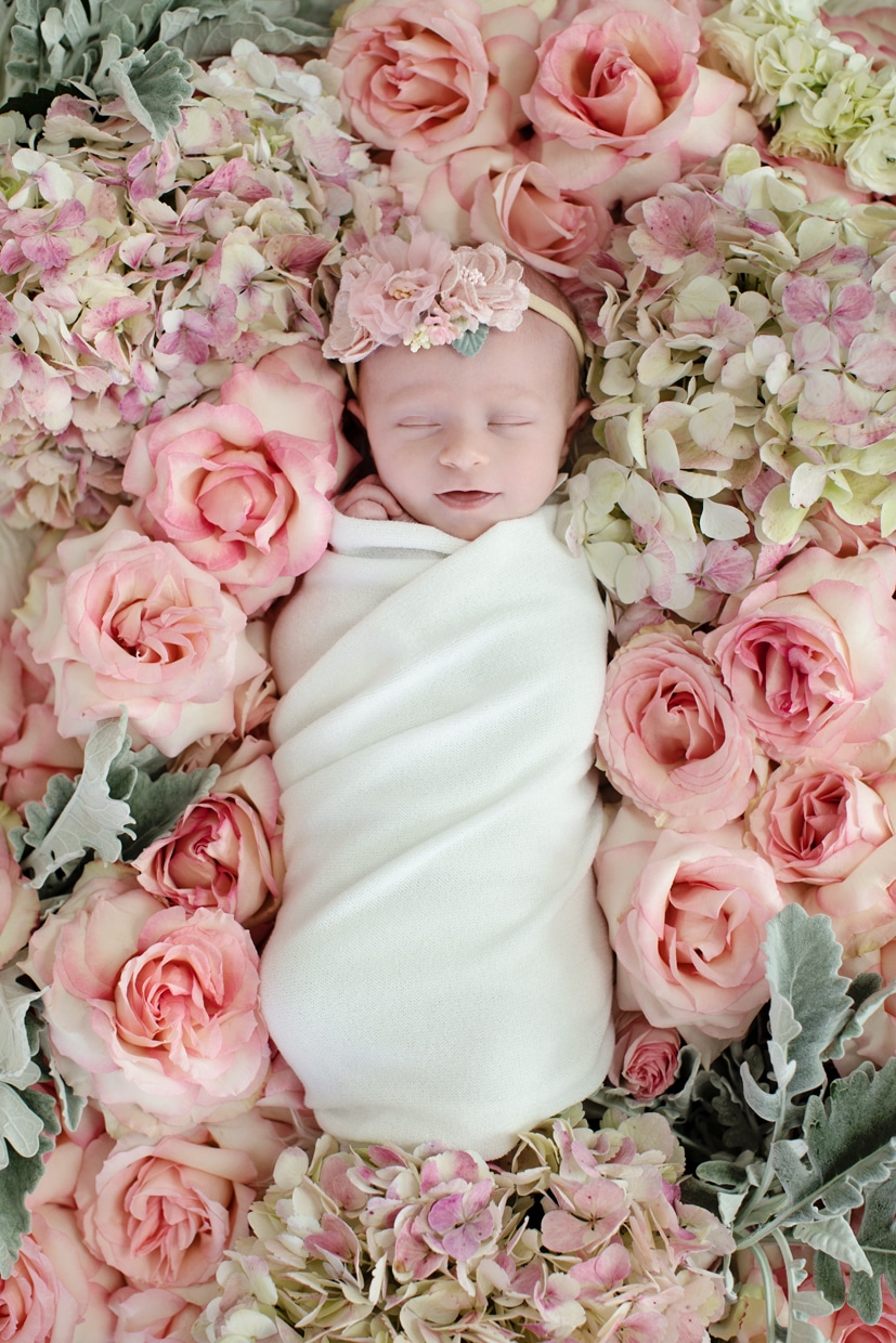 tiny newborn girl in flower bed