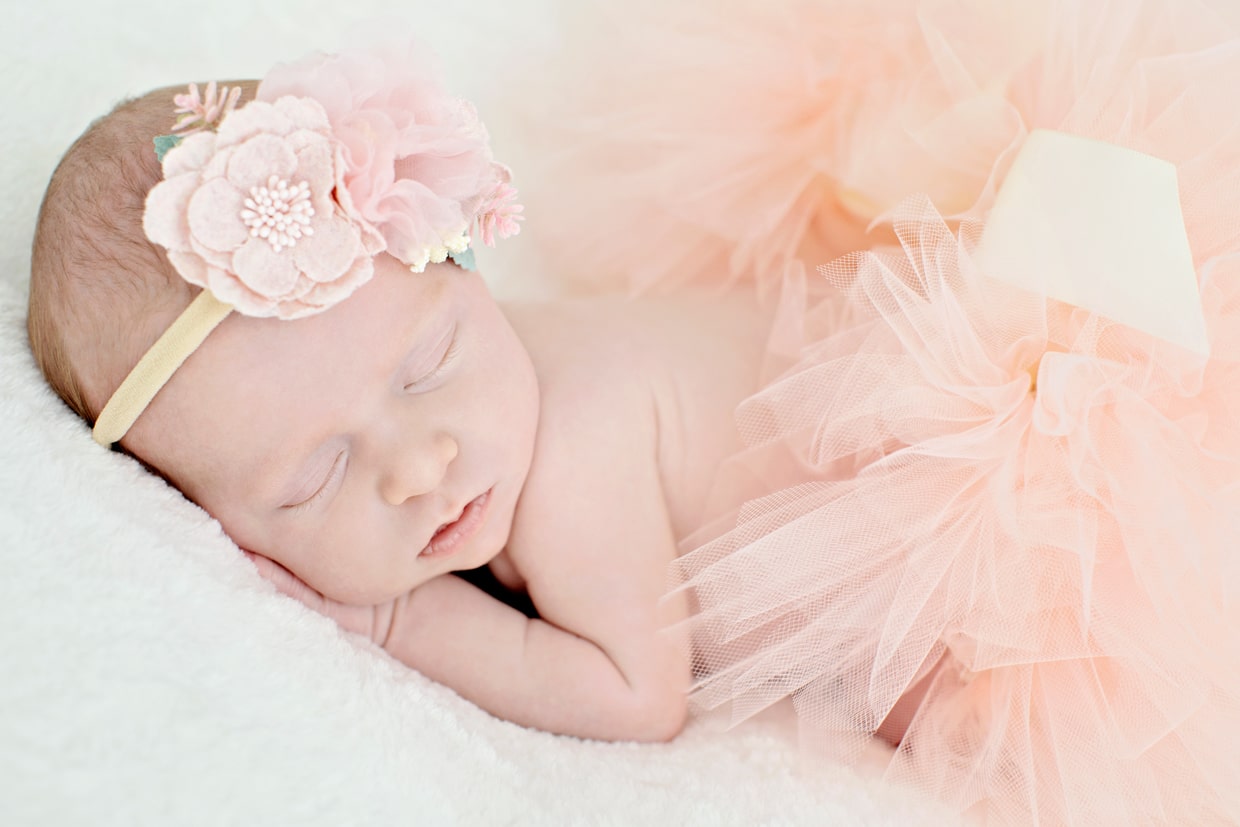 tiny newborn girl in pink tutu poses in dallas newborn photographers private studio