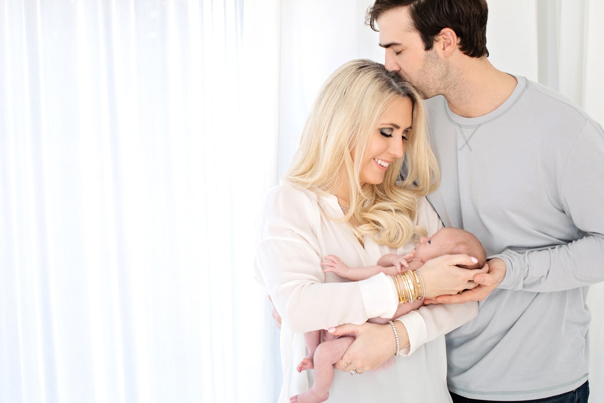 New mom and dad pose with newborn girl in dallas studio session