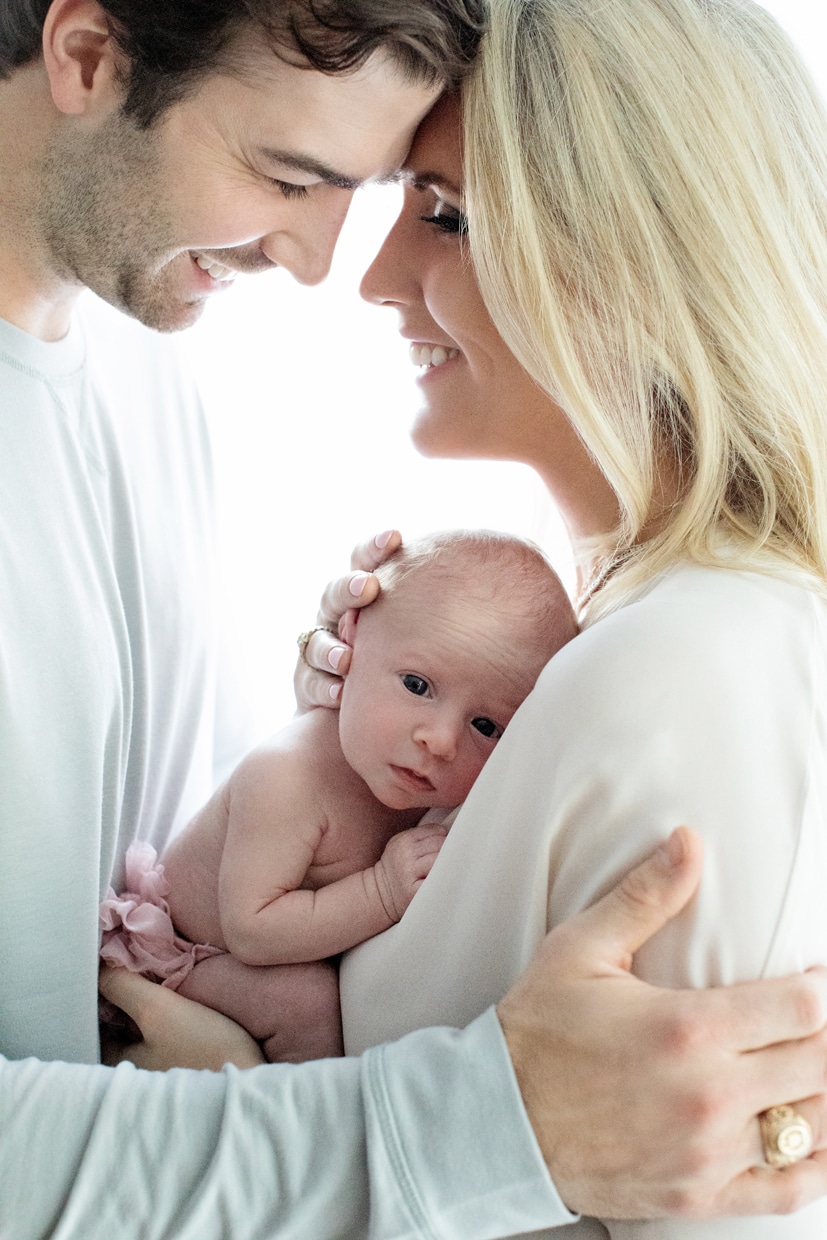 New mom and dad pose with newborn girl in dallas studio session