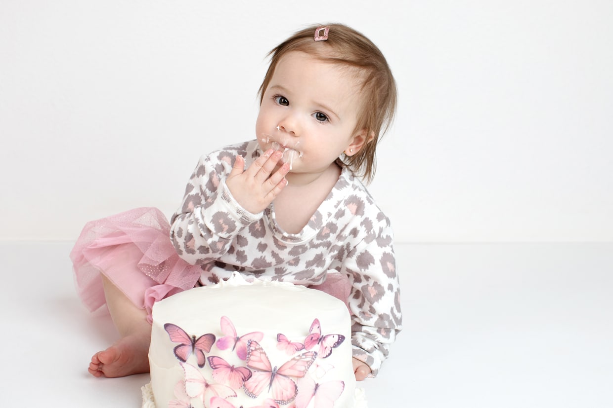little girl celebrates first birthday with fancy cake smash session in private studio