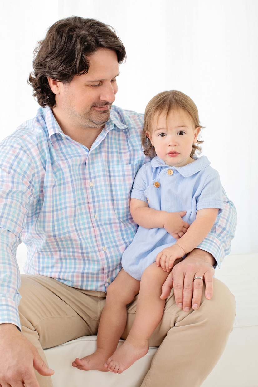 adorable little boy snuggled up with his dad in private studio