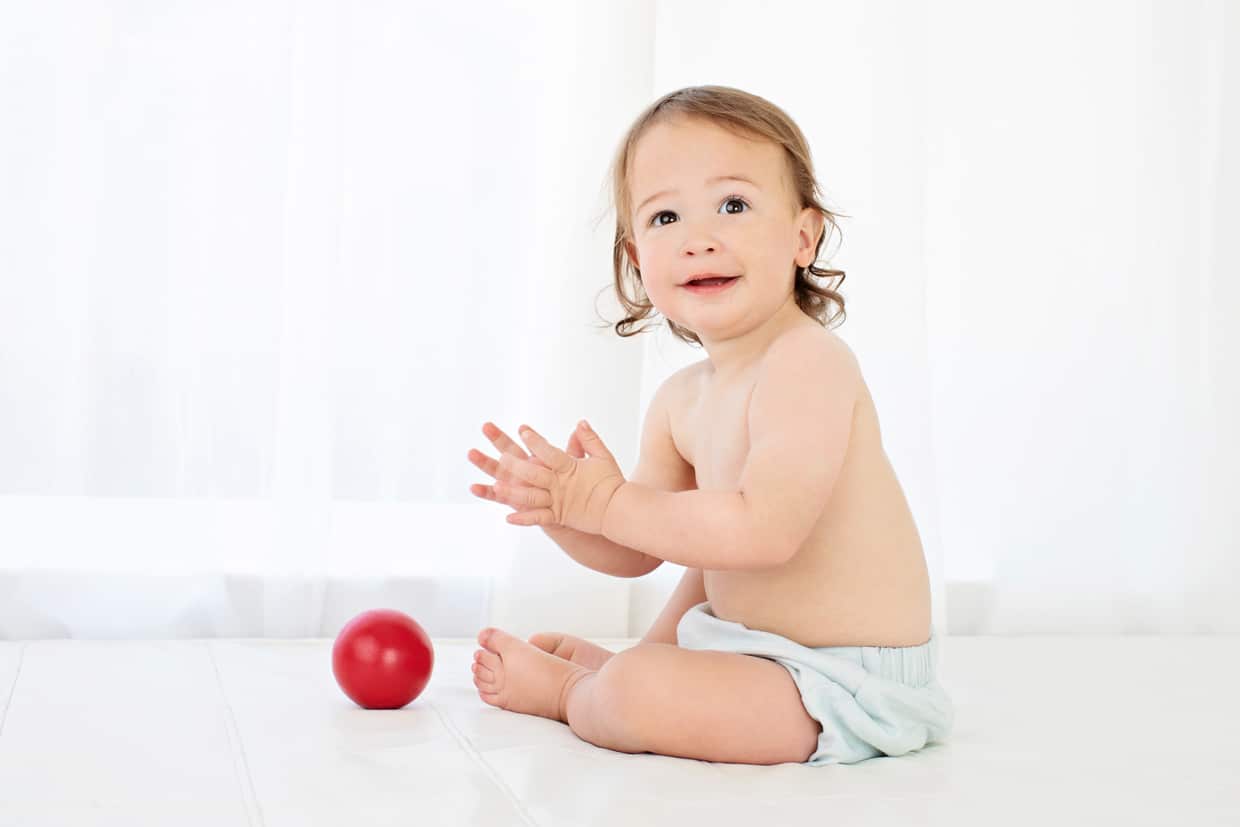 Little boy plays with his ball in studio