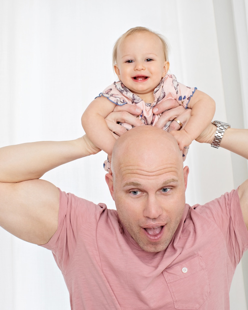 little girl snuggles up with dad for first birthday shoot in private studio