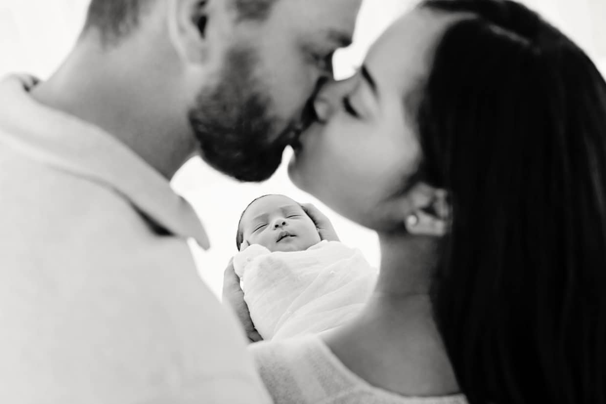 Mom and dad pose with newborn baby in dallas studio session