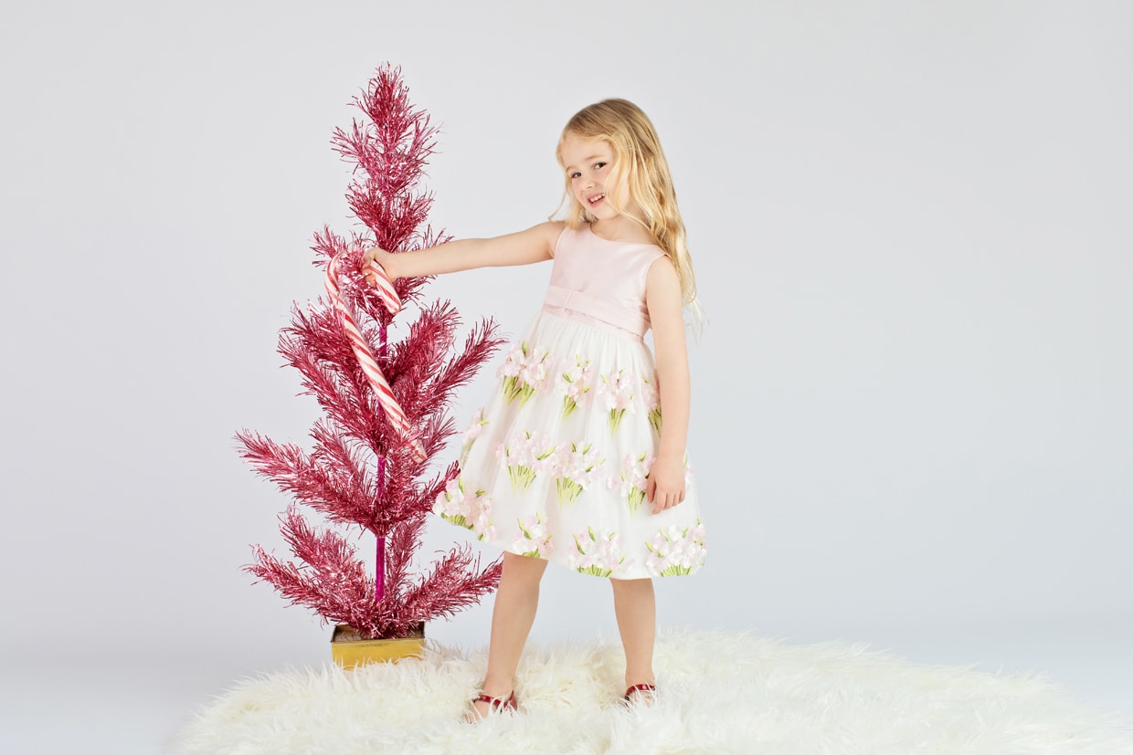 adorable kids posing in front of pink Christmas tree for the holidays