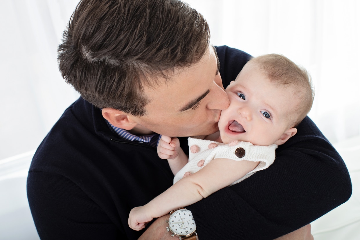 new dad gives newborn baby girl a smooch