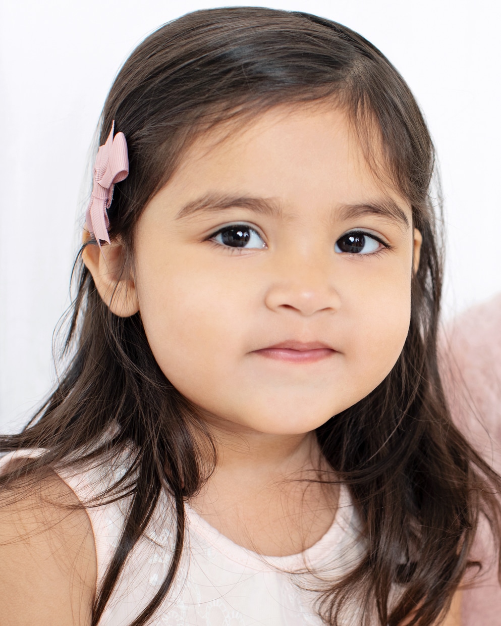 Close-up of gorgeous 2-year-old girl with pink bow in her hair | Dallas Studio Session