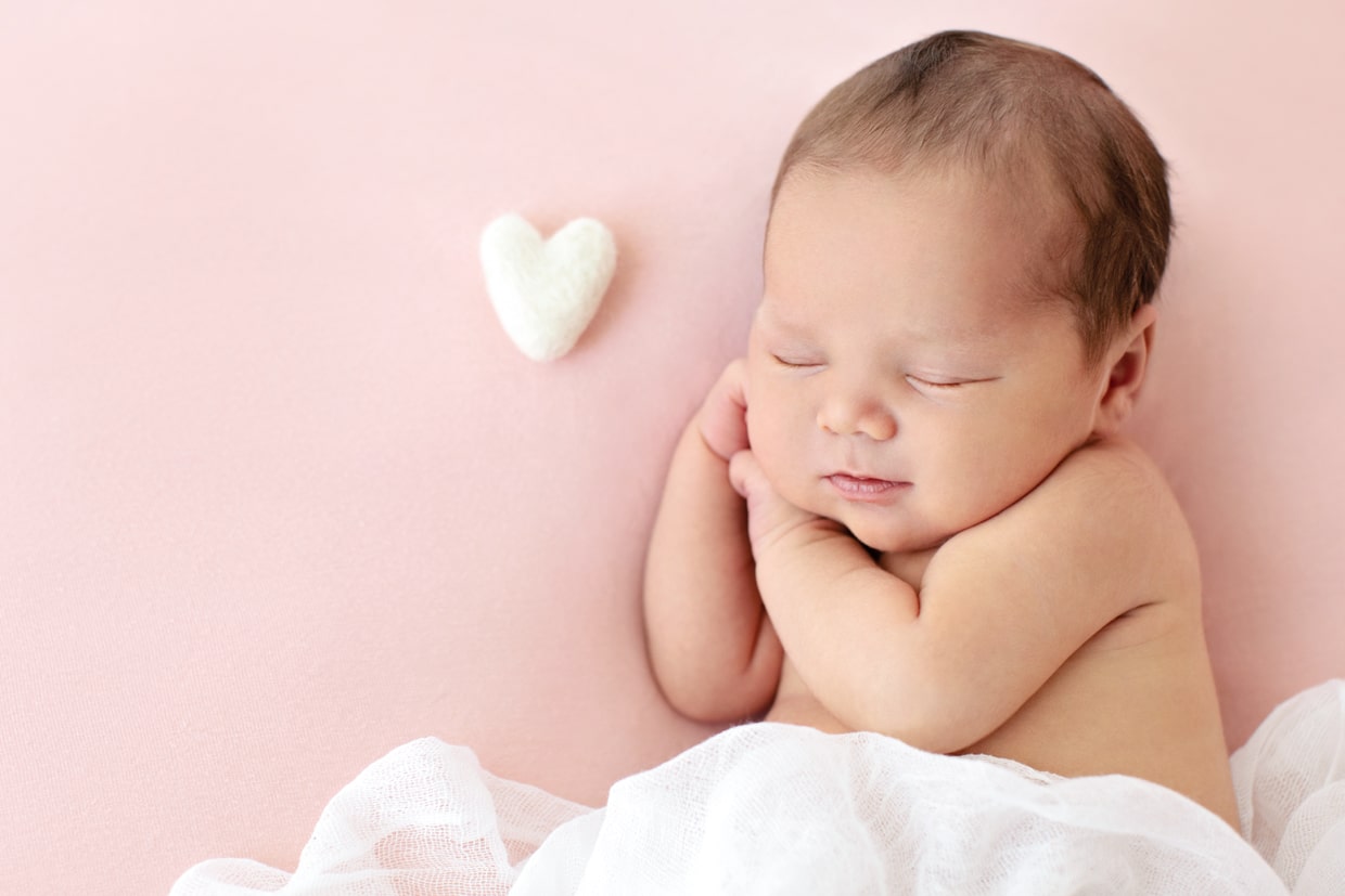cutest newborn celebrating the season of love in the studio on pink backdrop