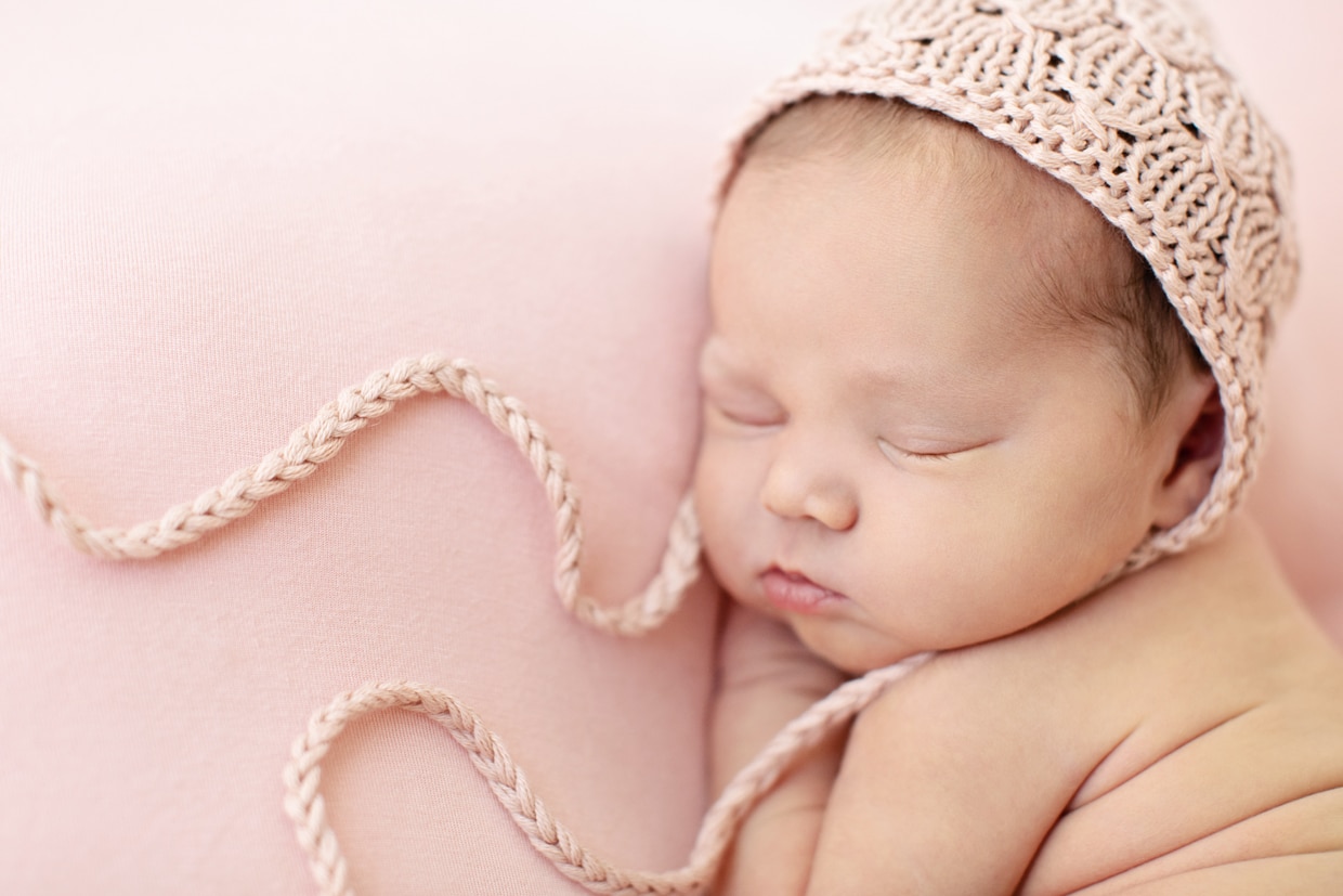 cutest newborn celebrating the season of love in the studio on pink backdrop