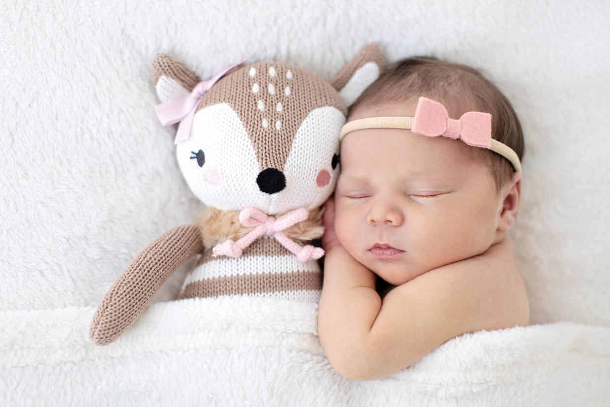 adorable newborn cozied up to stuffed animal
