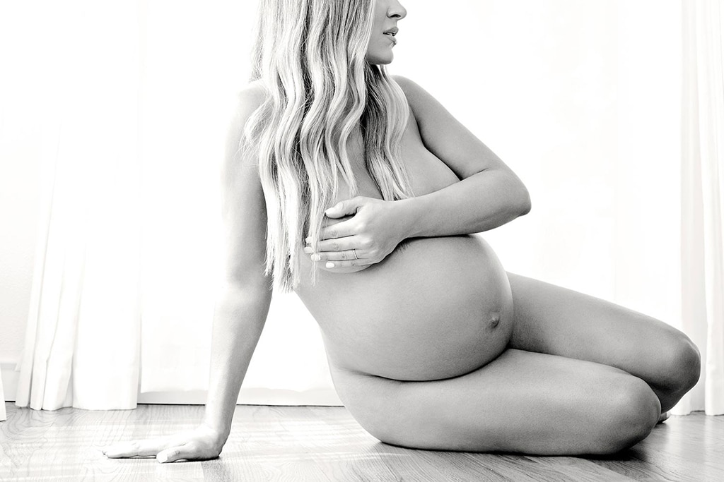 boudoir maternity photo of woman covered by hands