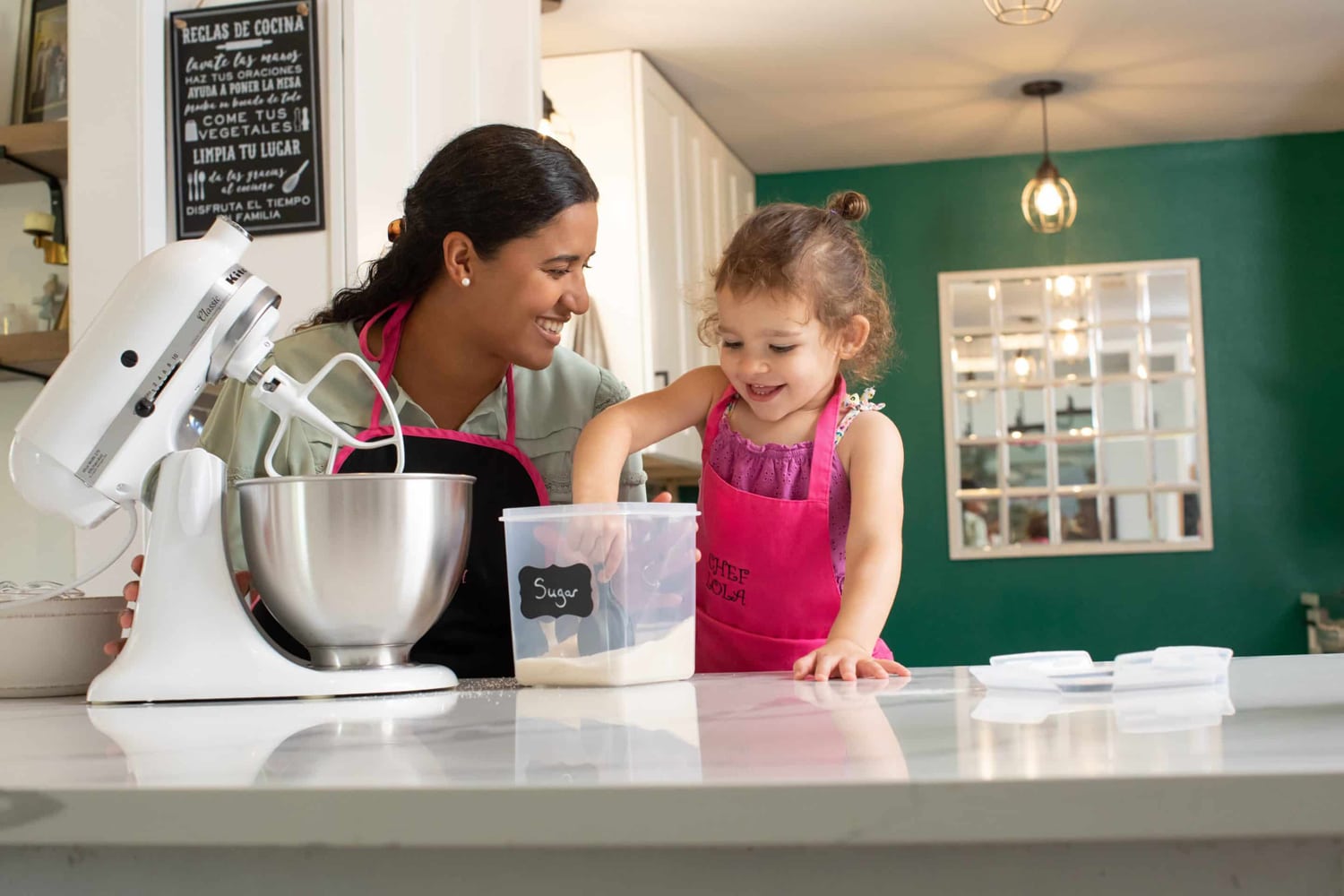 A little girl cooks in the kitchen with her mom.